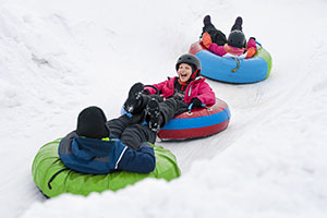 Kids having fun winter snow tubing