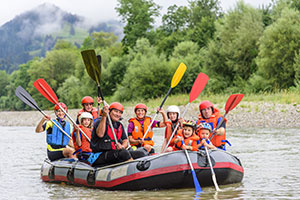 Large family with kids river rafting in calm river