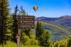 Park City Utah trail sign with hot air balloon in background
