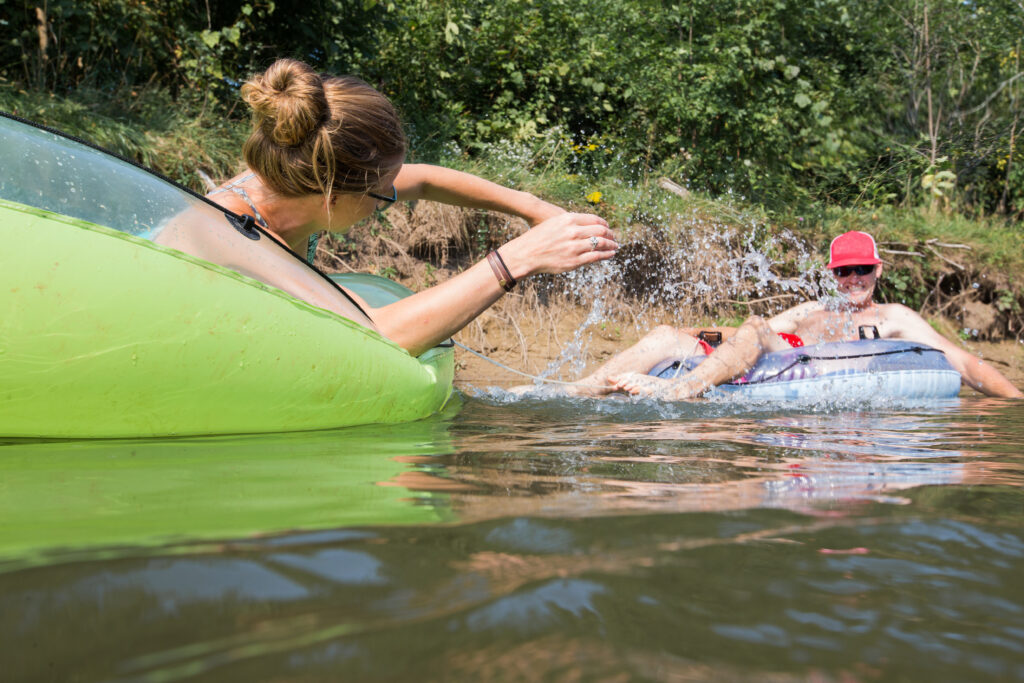 A couple take float in tubes down the river during the summer.